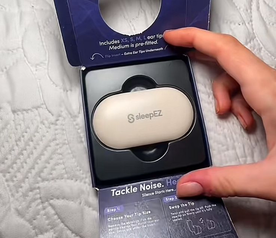 sleepEZ earbud case in packaging with a hand holding it on a textured surface